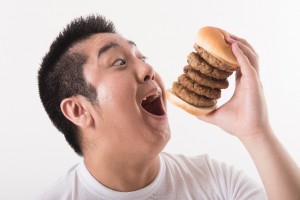 ハンバーガーを食べる男性
